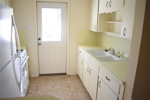 kitchen featuring white cabinets, sink, and white appliances