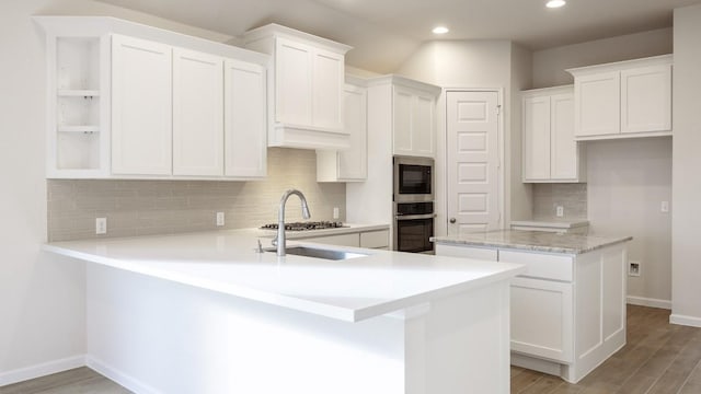 kitchen featuring a kitchen island, appliances with stainless steel finishes, white cabinets, and light wood-type flooring