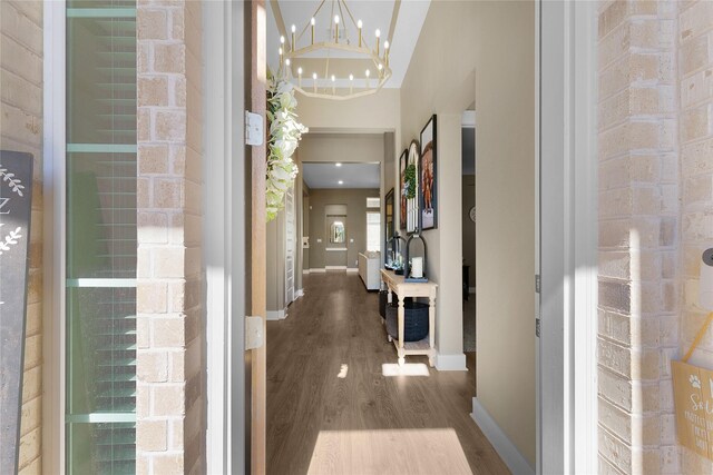 corridor featuring hardwood / wood-style flooring and an inviting chandelier