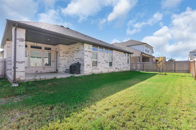 back of house with a patio area and a yard