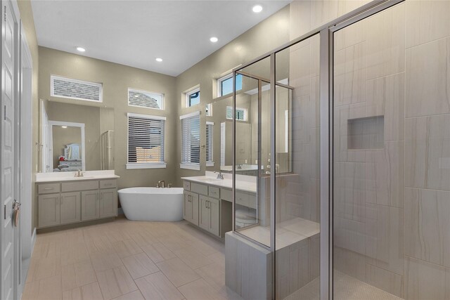 bathroom featuring independent shower and bath, tile patterned floors, and vanity