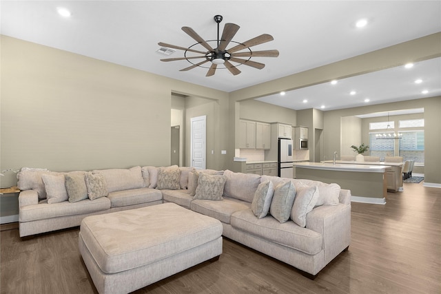 living room featuring sink, ceiling fan, and dark hardwood / wood-style floors