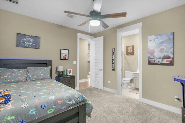 carpeted bedroom with ceiling fan and ensuite bath