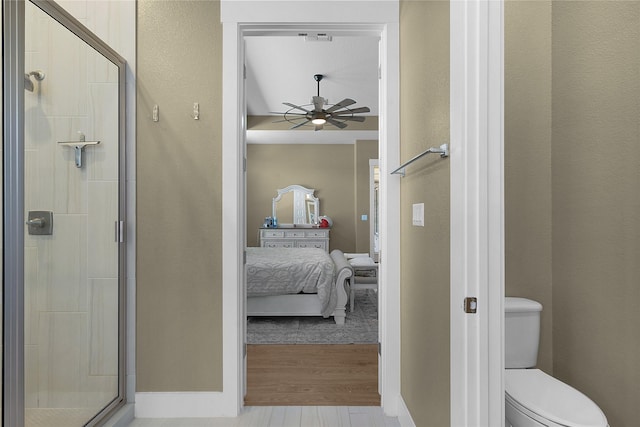 bathroom featuring hardwood / wood-style flooring, toilet, walk in shower, and ceiling fan