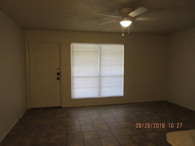 tiled spare room with ceiling fan