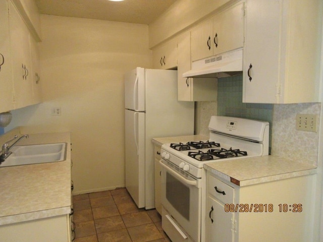 kitchen featuring tasteful backsplash, dark tile patterned floors, sink, and white gas range