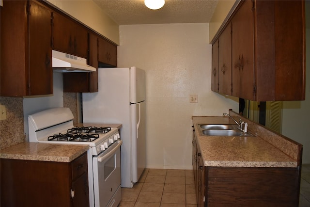 kitchen featuring white range with gas cooktop, dark brown cabinetry, a textured ceiling, sink, and light tile patterned flooring