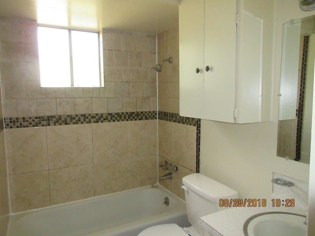 full bathroom with tiled shower / bath, toilet, and vanity