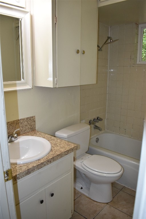 full bathroom featuring vanity, tile patterned flooring, toilet, and tiled shower / bath