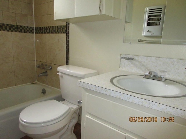 full bathroom featuring vanity, toilet, heating unit, and tiled shower / bath