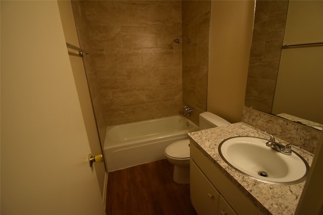 full bathroom with vanity, wood-type flooring, tiled shower / bath, and toilet