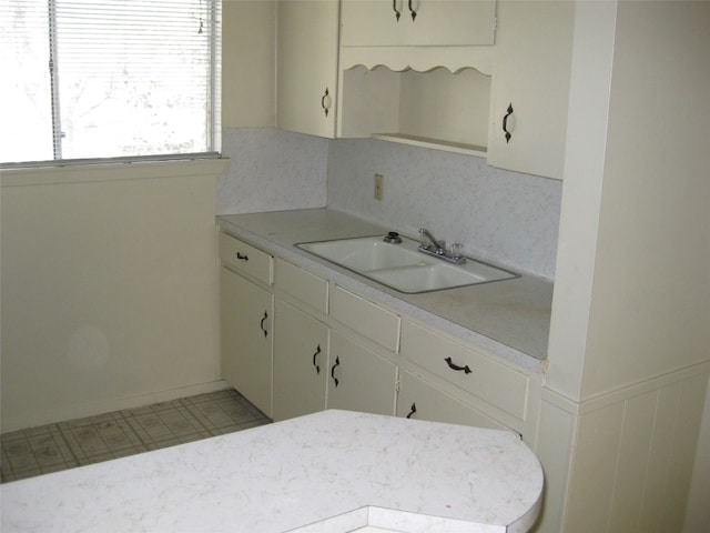 kitchen featuring white cabinets, sink, and tasteful backsplash