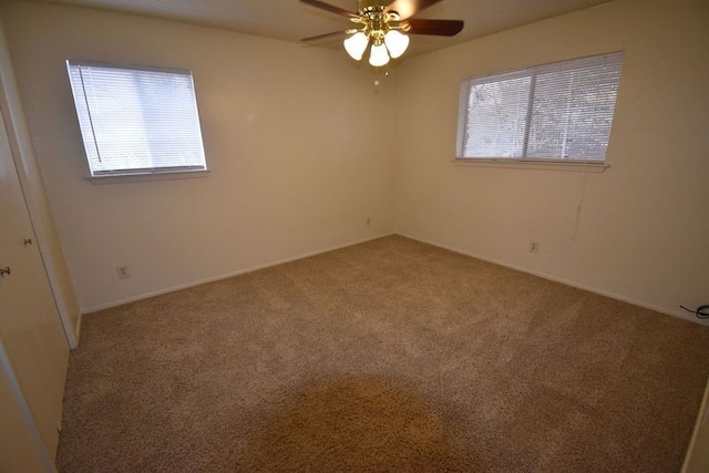 unfurnished room with ceiling fan and carpet