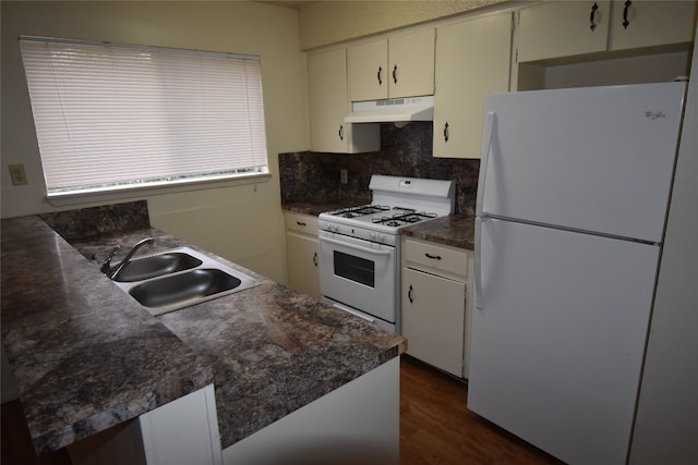 kitchen with sink, kitchen peninsula, tasteful backsplash, white appliances, and dark hardwood / wood-style flooring