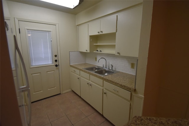 kitchen featuring decorative backsplash, sink, and light tile patterned floors