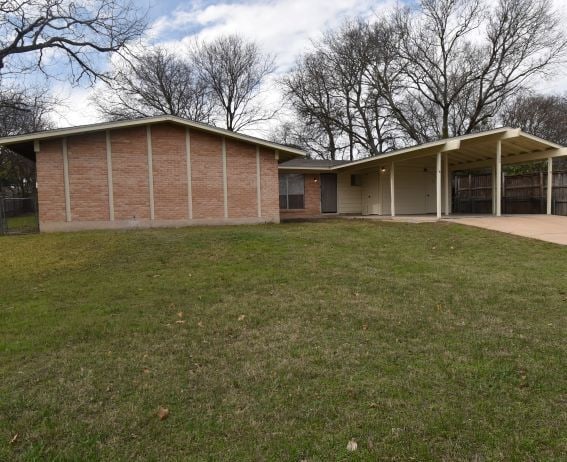 view of front facade featuring a front lawn and a carport