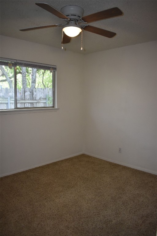 spare room with a textured ceiling, carpet floors, and ceiling fan