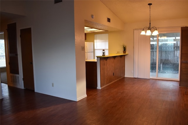 interior space with plenty of natural light, dark hardwood / wood-style floors, and vaulted ceiling