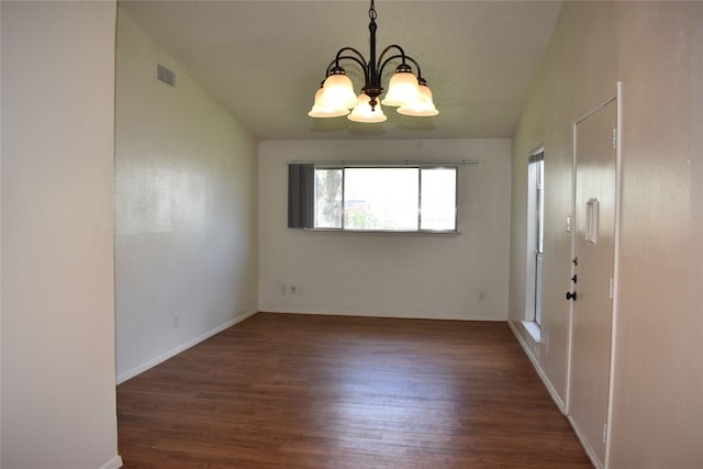 spare room featuring dark hardwood / wood-style flooring, lofted ceiling, and an inviting chandelier