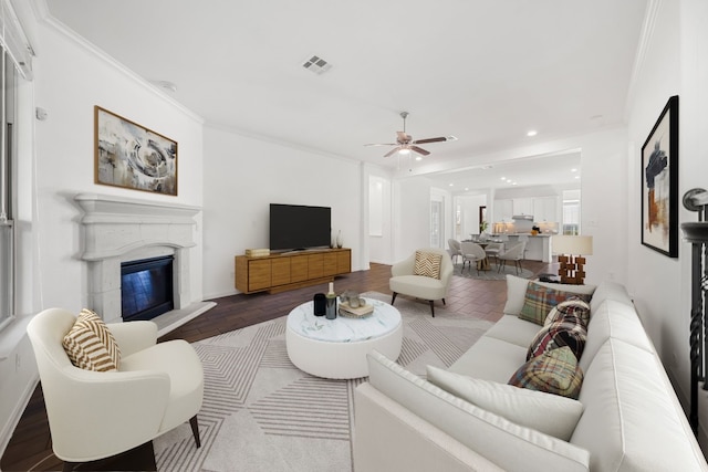 living room featuring ceiling fan, hardwood / wood-style floors, and ornamental molding