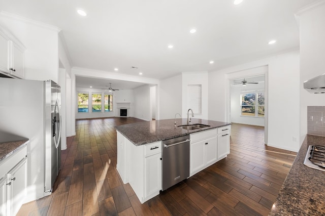 kitchen featuring sink, appliances with stainless steel finishes, dark stone counters, white cabinets, and dark hardwood / wood-style flooring