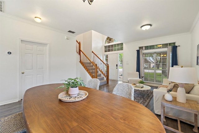 900 Laurel Cv, Buda, TX 78610 - dining area with stairway, dark wood finished floors, crown molding, and baseboards