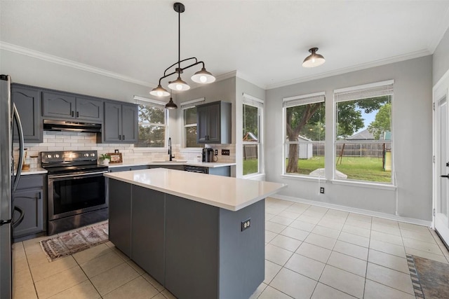 900 Laurel Cv, Buda, TX 78610 - kitchen with stainless steel appliances, light tile patterned floors, a sink, light countertops, and crown molding