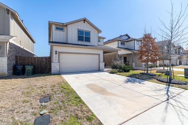 view of front of home with driveway, stone siding, an attached garage, fence, and board and batten siding