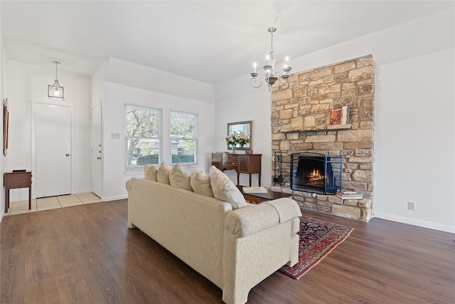 living room featuring hardwood / wood-style floors, a fireplace, and a notable chandelier