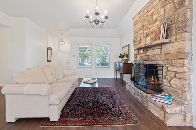 living room featuring a fireplace, dark hardwood / wood-style floors, vaulted ceiling, and a notable chandelier