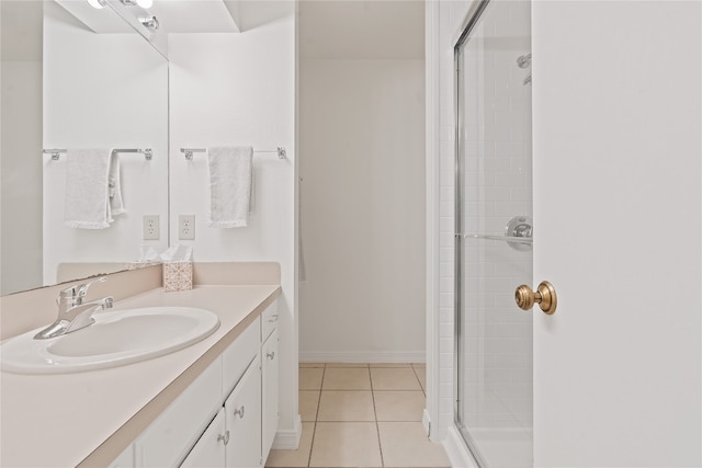 bathroom with walk in shower, vanity, and tile patterned floors