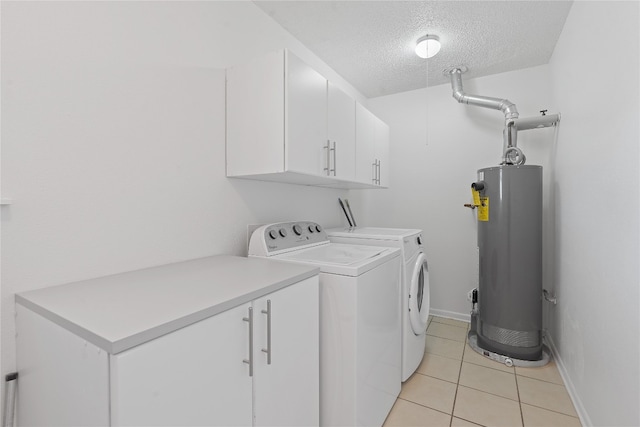 laundry room featuring cabinets, washer and dryer, a textured ceiling, light tile patterned floors, and water heater