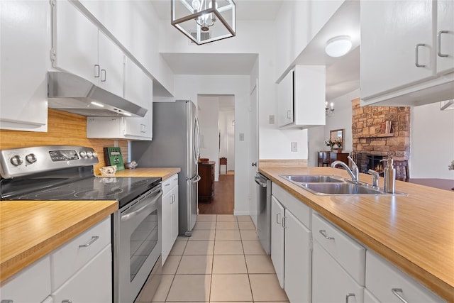 kitchen with white cabinetry, stainless steel appliances, and light tile patterned floors