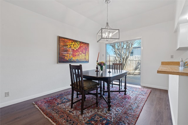 dining space with dark hardwood / wood-style flooring and a notable chandelier