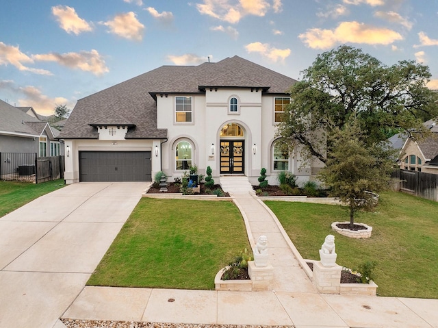 view of front of home with french doors, a front yard, and a garage