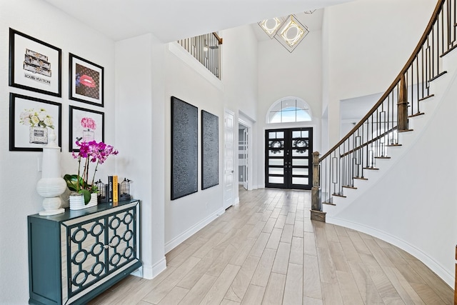 foyer entrance featuring a towering ceiling and french doors