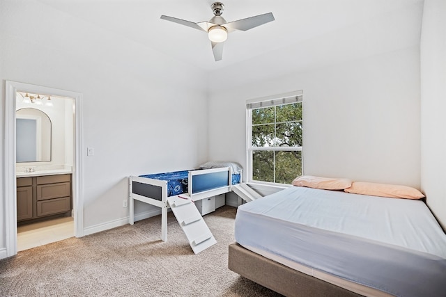 bedroom featuring light carpet, connected bathroom, ceiling fan, and sink