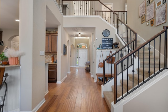 foyer entrance with wood-type flooring and a high ceiling