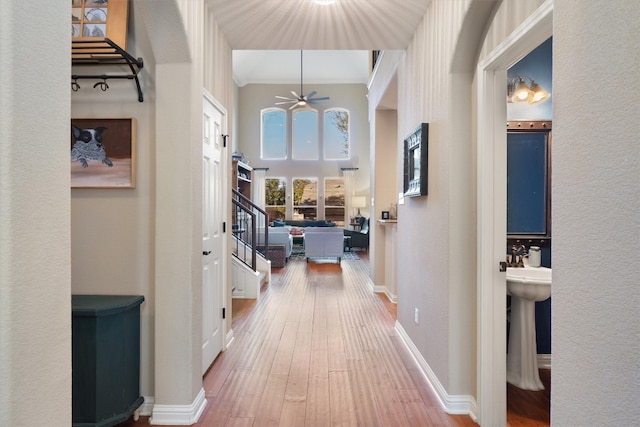 hallway with hardwood / wood-style floors and ornamental molding