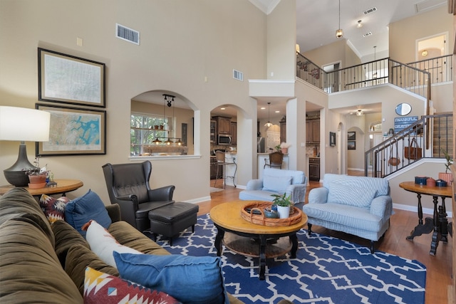 living room featuring a towering ceiling and wood-type flooring