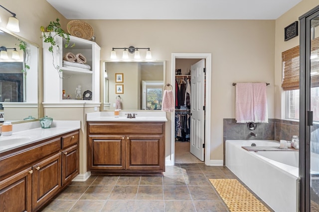 bathroom featuring tile patterned flooring, a bathtub, and vanity