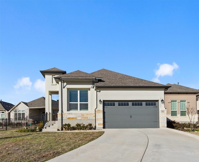 prairie-style house featuring a garage and a front yard