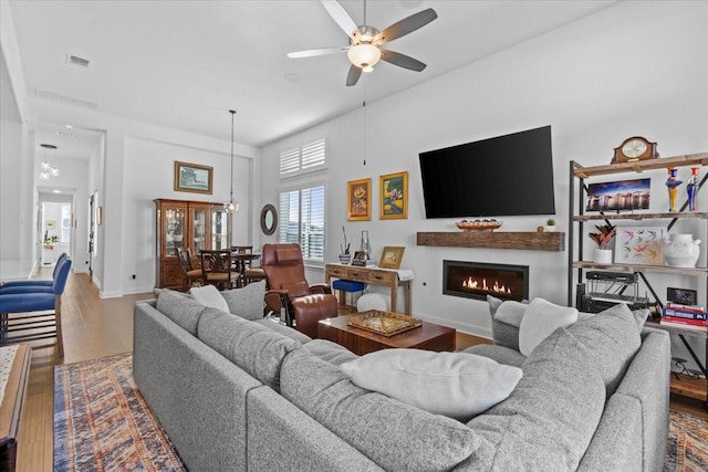 living room featuring hardwood / wood-style flooring, a high ceiling, and ceiling fan