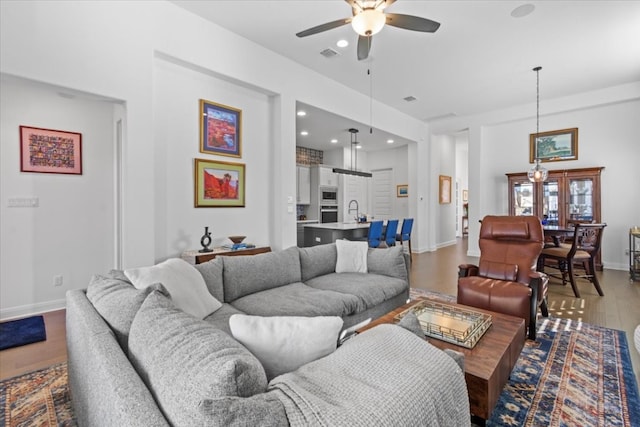 living room featuring ceiling fan, sink, wood-type flooring, and french doors