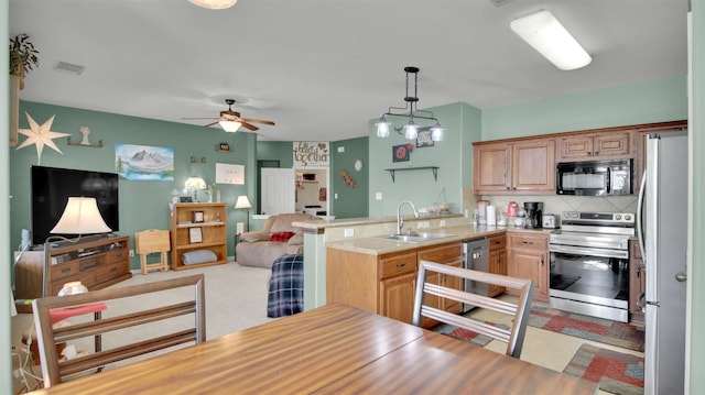 kitchen with tasteful backsplash, stainless steel appliances, hanging light fixtures, sink, and ceiling fan with notable chandelier