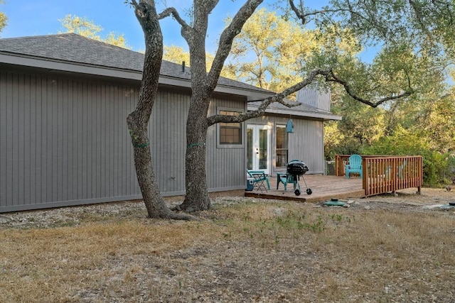 view of property exterior with a wooden deck and french doors