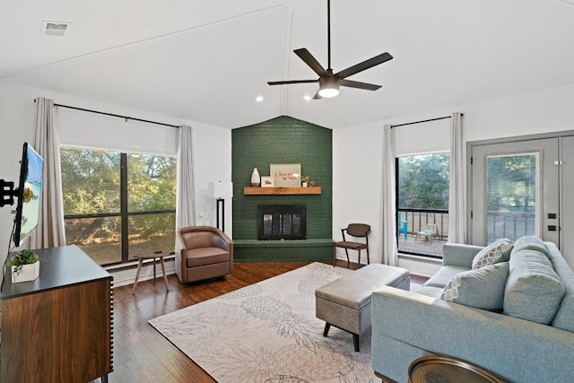 living room featuring a baseboard radiator, vaulted ceiling, and a wealth of natural light