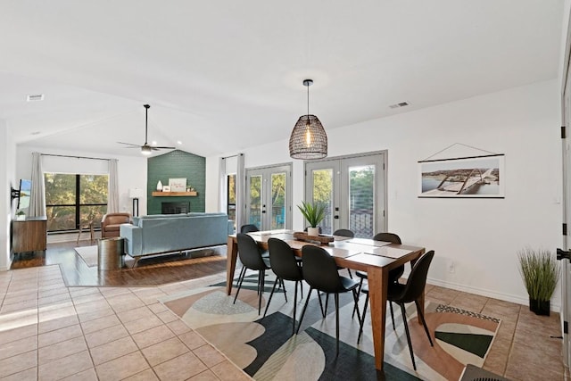 tiled dining space with vaulted ceiling, a wealth of natural light, ceiling fan, and french doors