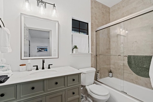 full bathroom with bath / shower combo with glass door, vanity, and toilet