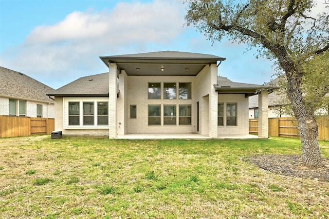 rear view of property with a patio and a yard